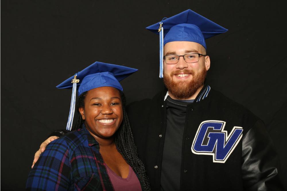 two friends with grad caps and gv varsity jacket